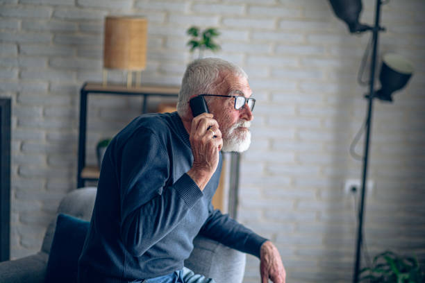 istock Senior man talking on the phone while he is home alone 2196696732