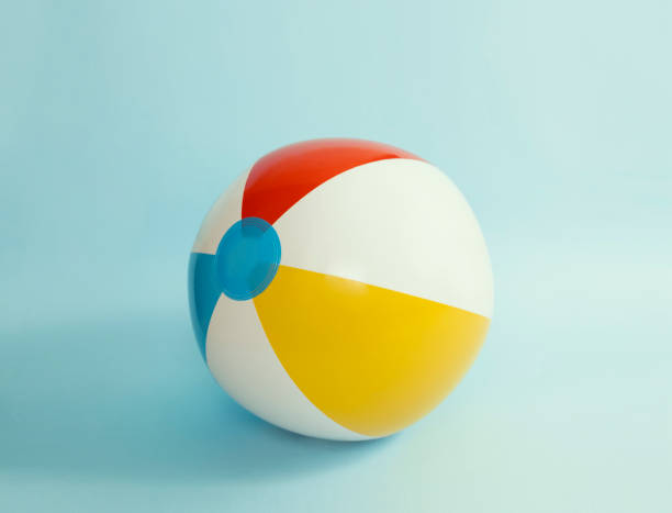 Beach ball on blue background, summer item, holiday resort concept. Travel object.