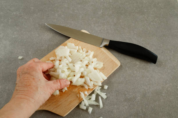istock A hand holds the freshly cut onion pieces. 2196698821