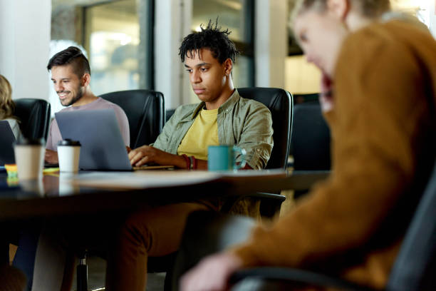 istock Young black man and his colleagues working on a computer in the office. 2196699816