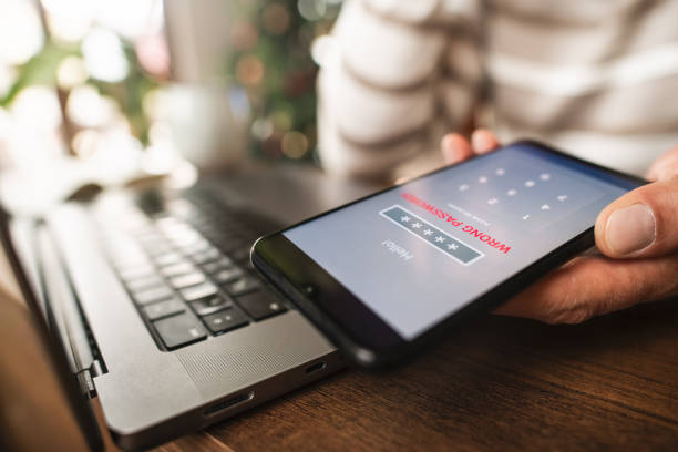 istock Man with smartphone and laptop trying to login. Data security, data leaks and unauthorised access concepts. 2196703579