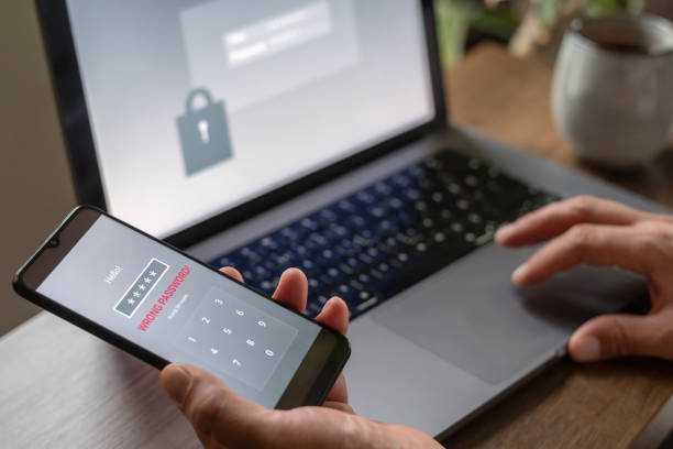 istock Man with smartphone and laptop trying to login. Data security, data leaks and unauthorised access concepts. 2196703890