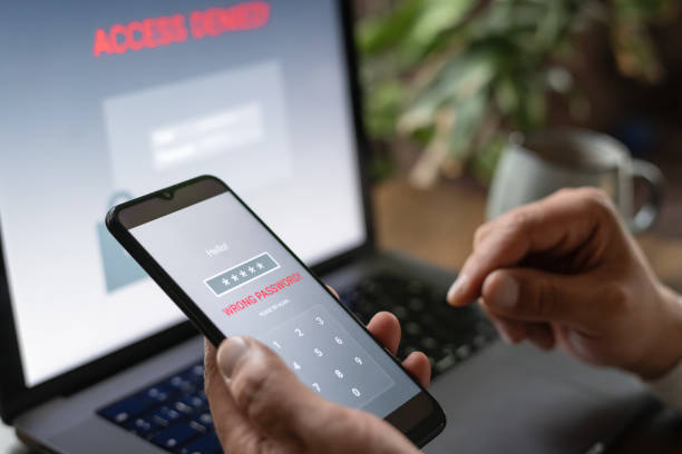 istock Man with smartphone and laptop trying to login. Data security, data leaks and unauthorised access concepts. 2196703894