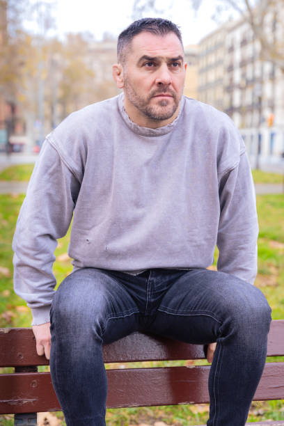 istock Thoughtful Man Sitting on a Park Bench in Casual Outfit.Vertical 2196704003