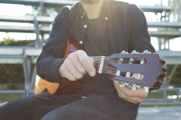 istock Hand Turns Wrench For Manual Tuning Of Classical Guitar 2196705757
