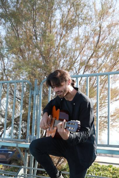 istock Man Plays Music With Classical Guitar Inexpensive Instrument 2196706457