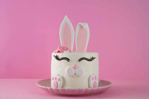 Easter bunny celebration cake on a plate on a pink background. Funny food idea. Copy space
