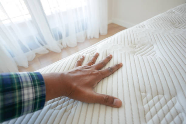 istock Hand touching and pressing orthopedic mattress on bed. 2196707486