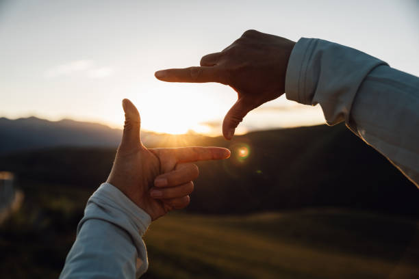 istock Hands in the shape of picture frame against the sunset 2196710032