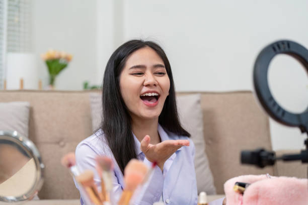 istock Beauty broker enthusiastically blowing kisses during a live broadcast while showcasing cosmetics 2196711677