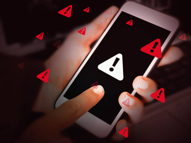 istock System warning and hacking attempt concept background with Man touching the Screen of smartphone. Red alert, cyber security threat, unauthorized access, error 2196711874