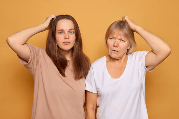 istock Two women stand side by side, looking puzzled with their hands on their heads. They display contrasting emotions, with one looking more bewildered 2196712893