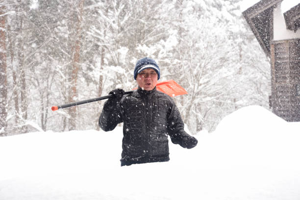 istock An old man clearing snow in a snowy area 2196714121