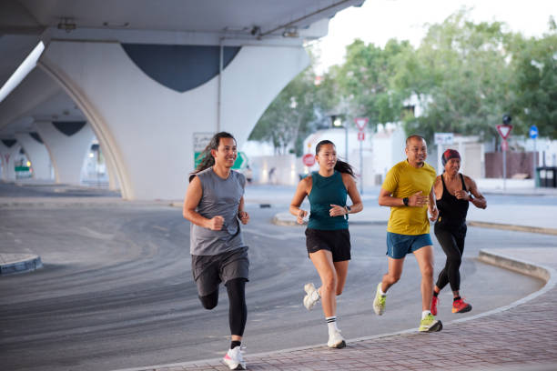 istock A group of four runners runs under a highway bridge. 2196716359