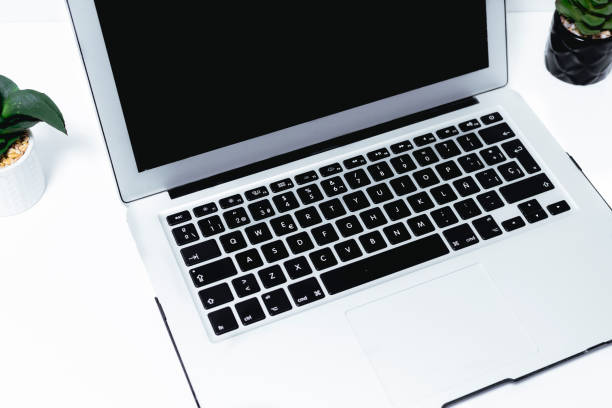 Laptop computer with blank screen on white table background, stock photo