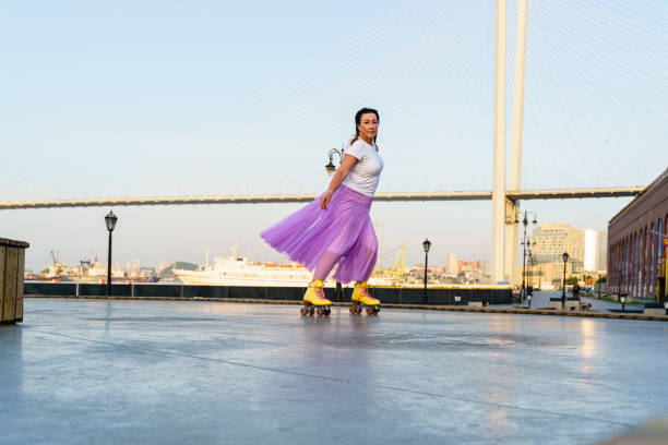 istock Happy young woman rollerskating in the park 2196717836