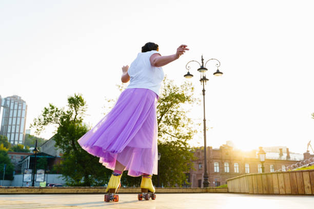 istock Happy young woman roller skating in the park 2196717931
