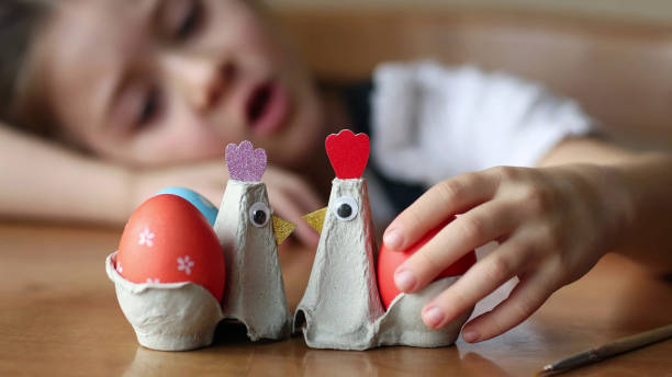 istock kids craft - egg stand made from packaging carton. child playing with chicken for Easter 2196718475