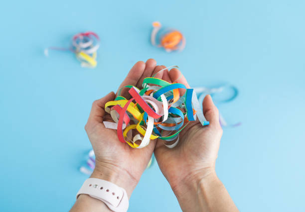 Hands with streamers of various colors on a blue background.
