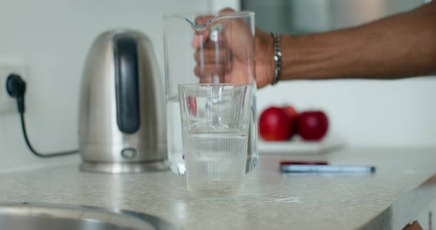 istock A man pours water into a glass 2196721703
