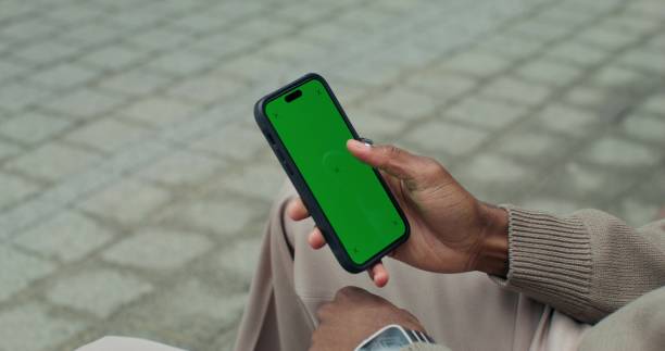 istock A man uses a mobile phone sitting outdoors 2196723520