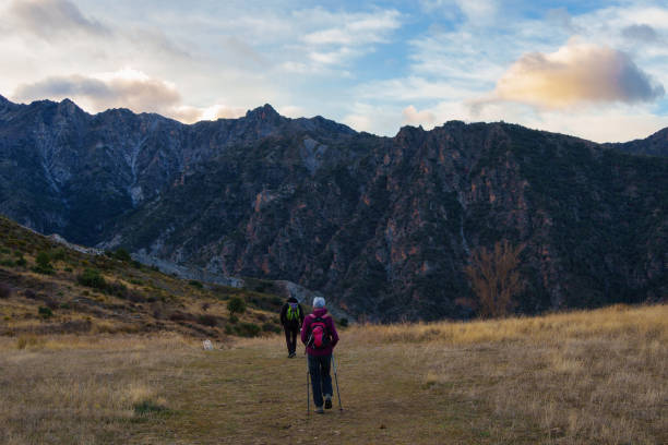 istock Hikers Walking on Mountain Trail at Sunset with Scenic Landscape 2196726280