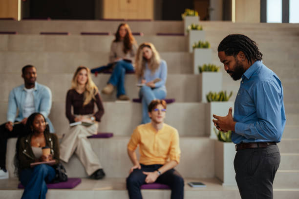 University professor giving a lecture to diverse group of students in modern auditorium
