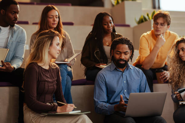 istock University professor explaining lesson to diverse group of students with laptop 2196730441