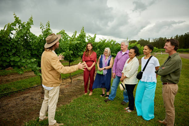 Winery tour guide with guests in vineyard