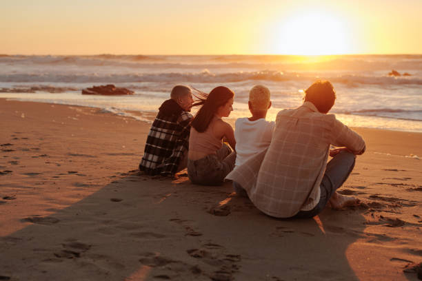 istock Friends enjoying golden sunset on sandy beach: 2196735623