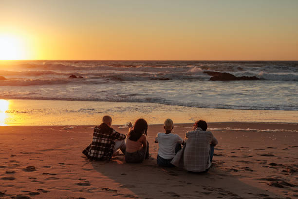 istock Friends enjoying golden sunset on sandy beach 2196735630