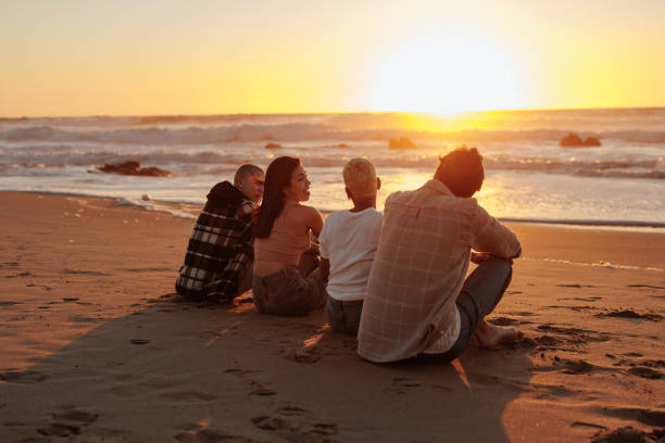 istock Friends enjoying golden sunset on sandy beach 2196735647