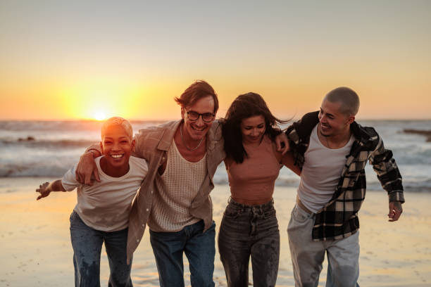 istock Happy friends walking on beach at sunset, enjoying summer vacation 2196735656