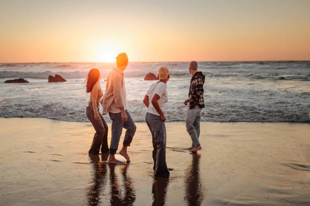istock Friends walking on the beach at sunset enjoying summer vacation 2196735661