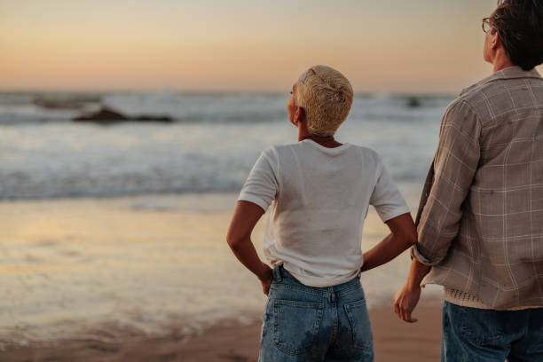 istock Couple admiring inspiring ocean sunset on beach 2196737132