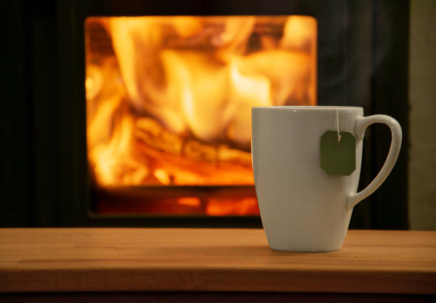 istock Cup of tea in front of a fireplace. 2196740249