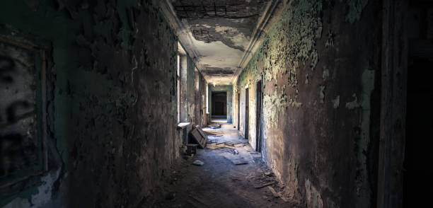 istock Long derelict corridor with crumbling walls and light flooding from broken windows. Symbolic of forgotten paths, isolation, and complexity of life journey through time 2196740622