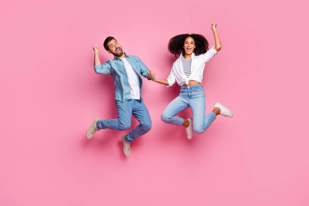 istock Happy young couple jumping on pink background, expressing joy and excitement 2196740981