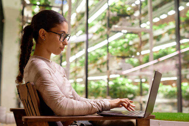 istock Woman Typing on Laptop in Indoor Garden Setting 2196741302