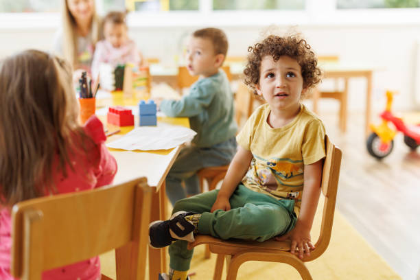 istock Children sit at the table in the kindergarten and play 2196743664