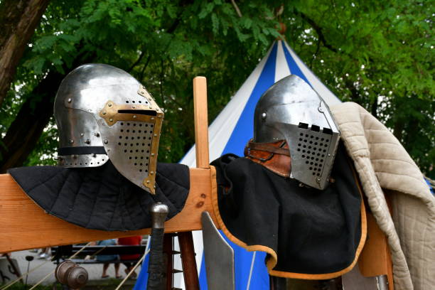 istock A close up on a medieval armor, including coat, gambeson, helmet, accessories, and swords, displayed on a wooden shelf in the middle of a forest or moor during a historic festival in Poland 2196744926