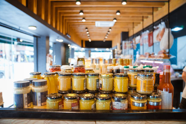 Jars on rack at illuminated convenience store. Merchandise is on display. Interior of delicatessen.
