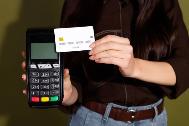 istock Close-up of a Woman Making a Contactless Payment Using a Card Reader with a Modern Khaki Background 2196746567
