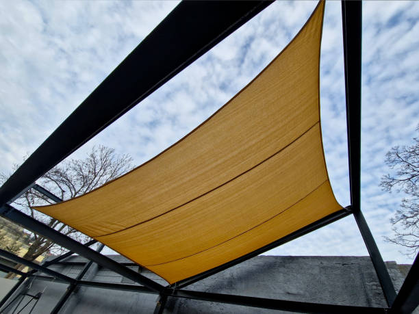 istock square canvas stretched, shading from sun, rain over terrace ofrestaurant, playground in kindergarten, platform of promenade. pergola with metallic gray beams , cable, electric, bulb, 2196750171