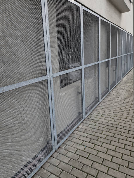 istock steel cladding of a building with a expanded metal lattice structure. galvanized gray nets protect the industrial building. contrast to a silver background, wall, sidewalk, lpg 2196750188