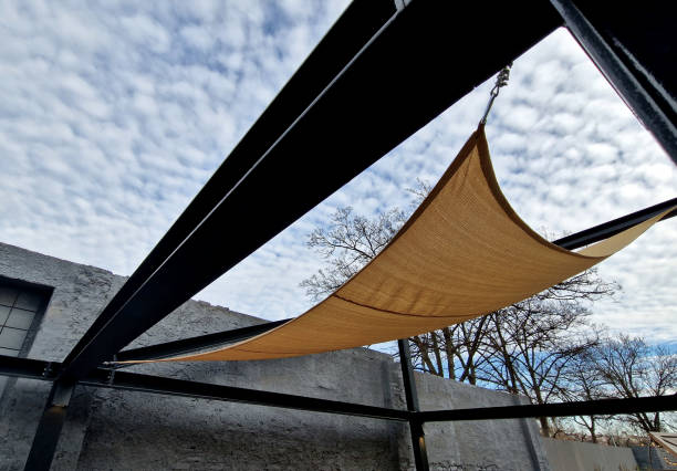 istock square canvas stretched, shading from sun, rain over terrace ofrestaurant, playground in kindergarten, platform of promenade. pergola with metallic gray beams , cable, electric, bulb, 2196750724
