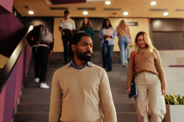istock Professor walking down university stairs with students behind him 2196756665