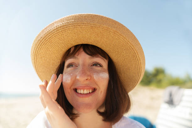 istock Young woman applying sunscreen at the beach 2196756961