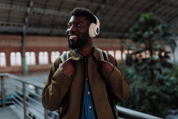 istock Smiling tourist wearing headphones and backpack in train station 2196757085