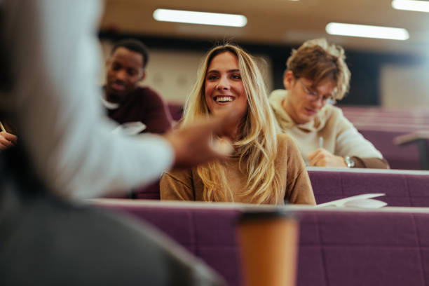 istock University student smiling and interacting with teacher during lecture 2196758496